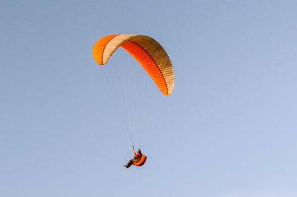 EIn Paraglider von unten aus gesehen vor blauem Himmel
